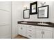 Bathroom with a double vanity with white cabinets and dark countertop and 3 mirrors at 4901 E Amelia Ave, Phoenix, AZ 85018