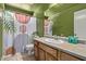 Stylish bathroom with colorful shower curtain, tile flooring, and solid-surface countertop at 5018 W Wikieup Ln, Glendale, AZ 85308