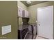 Well-organized laundry room featuring washer, dryer, cabinets and a door to the outside at 5018 W Wikieup Ln, Glendale, AZ 85308