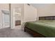 Comfortable bedroom with neutral walls, carpet flooring, and an adjoining bathroom with dual sinks at 5018 W Wikieup Ln, Glendale, AZ 85308