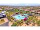 An aerial view of a luxurious community pool featuring water slides and palm trees, ideal for Gathering fun at 5637 S Parrish --, Mesa, AZ 85212