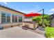 Relaxing backyard featuring a hot tub under a red umbrella, surrounded by lush greenery at 5637 S Parrish --, Mesa, AZ 85212