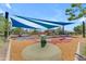 Community playground with sun shades, colorful play equipment, and soft surface flooring at 5637 S Parrish --, Mesa, AZ 85212