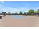Well-maintained tennis court with a blue playing surface, surrounded by fencing and lush landscaping at 5637 S Parrish --, Mesa, AZ 85212