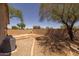 Large backyard with a block wall, outdoor fireplace, patio area, and desert landscaping creating a serene outdoor retreat at 718 E Devon Dr, Gilbert, AZ 85296