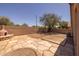 Spacious backyard featuring an outdoor fireplace, block wall, and a flagstone patio perfect for outdoor entertaining at 718 E Devon Dr, Gilbert, AZ 85296