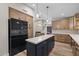 Open concept kitchen with hardwood floors, large island, and stainless steel appliances at 718 E Devon Dr, Gilbert, AZ 85296