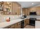 Modern kitchen with quartz countertops, mosaic tile backsplash, stainless appliances, and glass front cabinets at 718 E Devon Dr, Gilbert, AZ 85296