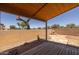 Covered patio with a wooden deck and a brick fireplace in the backyard at 718 E Devon Dr, Gilbert, AZ 85296
