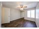 Bedroom with ceiling fan, closet, window, and wood-look flooring at 747 S Extension Rd # 115, Mesa, AZ 85210