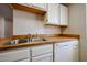 Bright kitchen featuring white cabinetry, stainless steel sink, and a built-in dishwasher at 747 S Extension Rd # 115, Mesa, AZ 85210