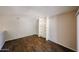 Empty living room with dark wood floors and white built in shelves on one wall at 747 S Extension Rd # 115, Mesa, AZ 85210