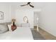 Sunlit bedroom features a ceiling fan, decorative mirror, and a hallway leading to other rooms at 7620 N 12Th Pl, Phoenix, AZ 85020