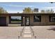 The front of this home features a gravel yard, walkway lighting, and a modern glass front door at 7620 N 12Th Pl, Phoenix, AZ 85020