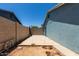 Concrete backyard under construction with block fence and blue exterior at 8042 W Mariposa Dr, Phoenix, AZ 85033