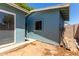 Exterior view of a blue house in a backyard with dirt and scattered leaves at 8042 W Mariposa Dr, Phoenix, AZ 85033