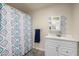 This bathroom showcases a vanity with sink, mirror, and shower with a decorative curtain at 8042 W Mariposa Dr, Phoenix, AZ 85033