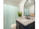 Modern bathroom featuring a granite countertop vanity, black faucet, and shower with blue curtain at 8042 W Mariposa Dr, Phoenix, AZ 85033