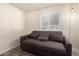 Cozy bedroom with wood-look floors, a window, and a comfortable gray sofa bed at 8042 W Mariposa Dr, Phoenix, AZ 85033