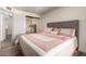 Bedroom with a large, plush bed, sliding mirror closet doors, and wood-look flooring at 8042 W Mariposa Dr, Phoenix, AZ 85033