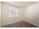 Empty bedroom with wood-look floors, a window with blinds, and light-colored walls at 8042 W Mariposa Dr, Phoenix, AZ 85033