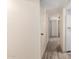 Bright hallway with wood-look floors and white walls leading to a kitchen at 8042 W Mariposa Dr, Phoenix, AZ 85033
