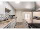 Contemporary kitchen with grey cabinetry, stainless hood, light countertops, and view to living space at 8042 W Mariposa Dr, Phoenix, AZ 85033