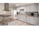 Bright kitchen featuring grey cabinets, patterned backsplash, an island cooktop, and stainless steel appliances at 8042 W Mariposa Dr, Phoenix, AZ 85033