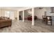 Bright, open-concept living space with wood-look flooring, multiple seating areas and easy kitchen access at 8042 W Mariposa Dr, Phoenix, AZ 85033