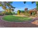 Expansive backyard with lush green lawn, mature trees, brick border, and a charming, inviting atmosphere at 8604 S Oak St, Tempe, AZ 85284