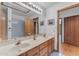 Bathroom with a double sink, a large mirror, a tiled shower and tub, and wood-toned cabinets at 8604 S Oak St, Tempe, AZ 85284