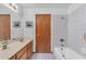 Bright bathroom featuring a tub with shower, a sink with a large mirror, and neutral-toned walls at 8604 S Oak St, Tempe, AZ 85284