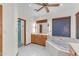 Bright bathroom with jacuzzi tub, wood cabinets, and large mirror with Hollywood-style lighting at 8604 S Oak St, Tempe, AZ 85284