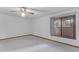Bright bedroom with neutral carpet, ceiling fan, a window and slider door with outside view at 8604 S Oak St, Tempe, AZ 85284