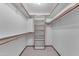 Walk-in closet with built-in shelving and wooden rods for efficient storage solutions at 8604 S Oak St, Tempe, AZ 85284