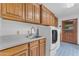 Functional laundry room with modern washer and dryer, sink, ample cabinet space, and blue-tiled flooring at 8604 S Oak St, Tempe, AZ 85284