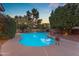 Backyard oasis features a sparkling pool with lush landscaping and ambient lighting, perfect for relaxing and entertaining at 8604 S Oak St, Tempe, AZ 85284