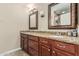 Bathroom vanity featuring dual sinks, granite countertops and framed mirrors with decorative lighting at 8620 E Sells Dr, Scottsdale, AZ 85251