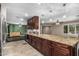 Gourmet kitchen featuring granite counters, dark wood cabinets and stainless steel appliances, open to the living areas at 8620 E Sells Dr, Scottsdale, AZ 85251