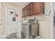 Convenient laundry room with stainless steel washer and dryer, upper cabinets, and tile floors at 8620 E Sells Dr, Scottsdale, AZ 85251