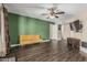 Bright living room with dark floors, olive accent wall, modern ceiling fan and a comfortable yellow couch at 8620 E Sells Dr, Scottsdale, AZ 85251