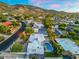 Aerial view of a well-maintained home with a pool, tennis court, and mountain views at 908 W Pershing Ave, Phoenix, AZ 85029