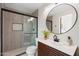 Nicely renovated bathroom with walk-in shower, modern vanity and decorative round mirror at 908 W Pershing Ave, Phoenix, AZ 85029