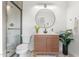 Modern bathroom featuring wood vanity, vessel sink, large round mirror and shower with glass door at 908 W Pershing Ave, Phoenix, AZ 85029
