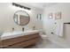 Bright bathroom with floating vanity, modern fixtures, round mirror, and decorative wall art at 908 W Pershing Ave, Phoenix, AZ 85029