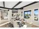 Well lit dining room with dark wood beams, neutral colors, and view to living room and outdoors at 908 W Pershing Ave, Phoenix, AZ 85029