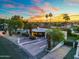 Stunning home with desert landscaping, paved driveway, and palm trees against a vibrant sunset sky at 908 W Pershing Ave, Phoenix, AZ 85029