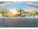 Desert home with palm trees, cactus, a circular driveway, and mountain backdrop at sunset at 908 W Pershing Ave, Phoenix, AZ 85029