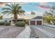 Charming single-story home showcasing desert landscaping, a two-car garage, and a grand palm tree against a serene sky at 908 W Pershing Ave, Phoenix, AZ 85029