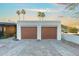 Detached two-car garage with decorative doors and a view of palm trees at 908 W Pershing Ave, Phoenix, AZ 85029
